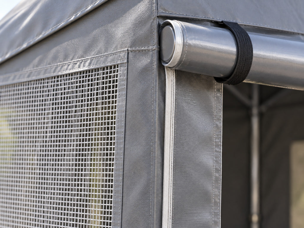 Détail du grillage d'une fenêtre et de la porte enroulable, tente grise