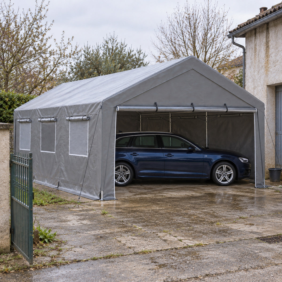 Tente-garage 4 x 6 m grise à fenêtres maille sur dalle ancienne, break bleu nuit abrité
