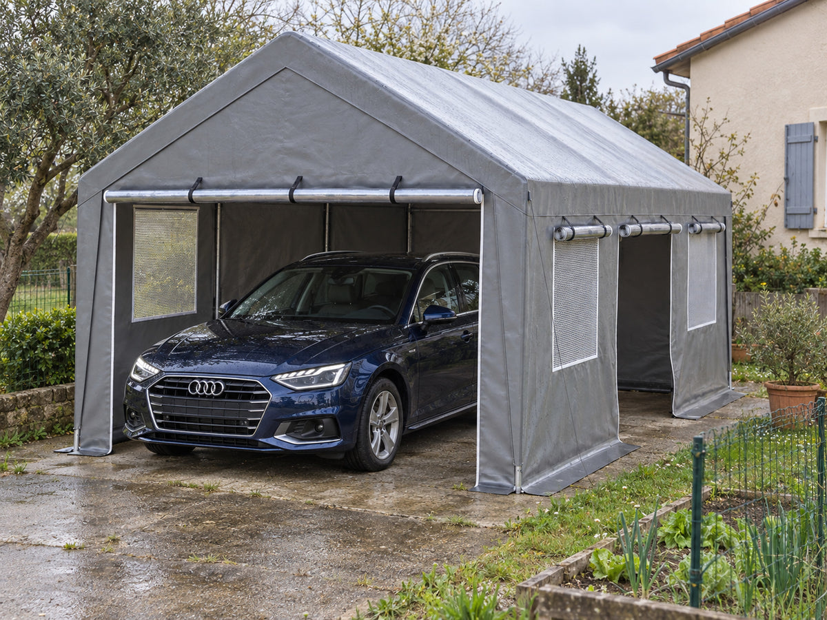 Tente-garage 4 x 6 m grise fermée à fenêtres maille installée sur une allée, break abrité