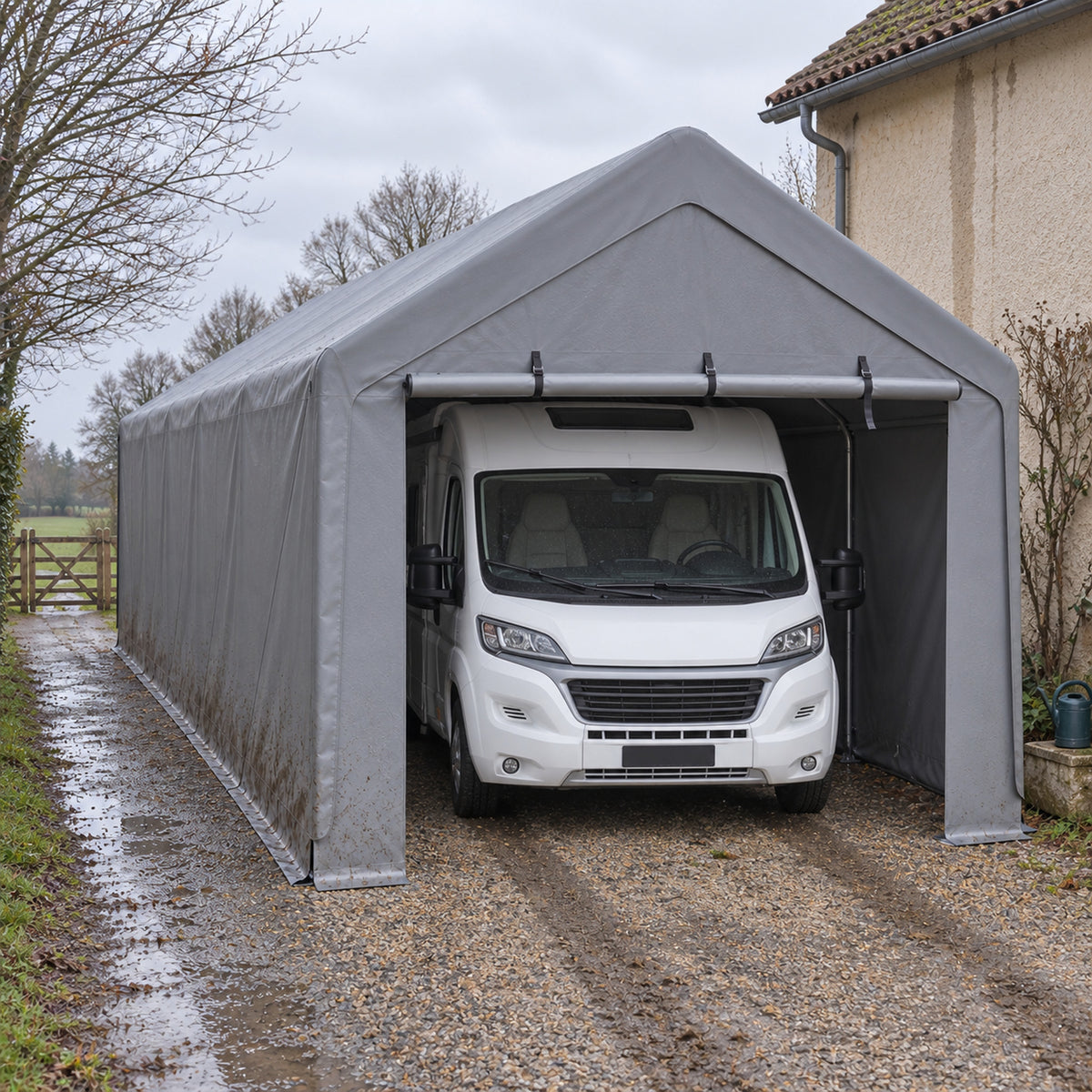Tente-garage 4 x 7,6 m grise pour camping-car, camping-car profilé blanc abrité sur allée en gravier